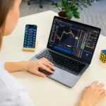 mulher analisando seus investimentos no laptop